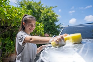 Women washing cars at home on vacation.