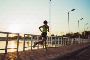 公園でジョギングするアジア人女性。朝のスピードの瞬間