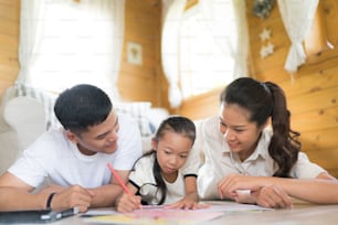 Father and mother Teaching children to do their homework at home