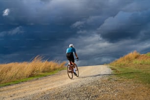 悪天候の日に砂利道で練習するサイクリスト