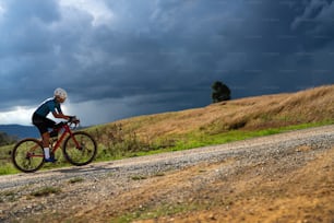 Ciclistas praticando em estradas de cascalho em dia de mau tempo