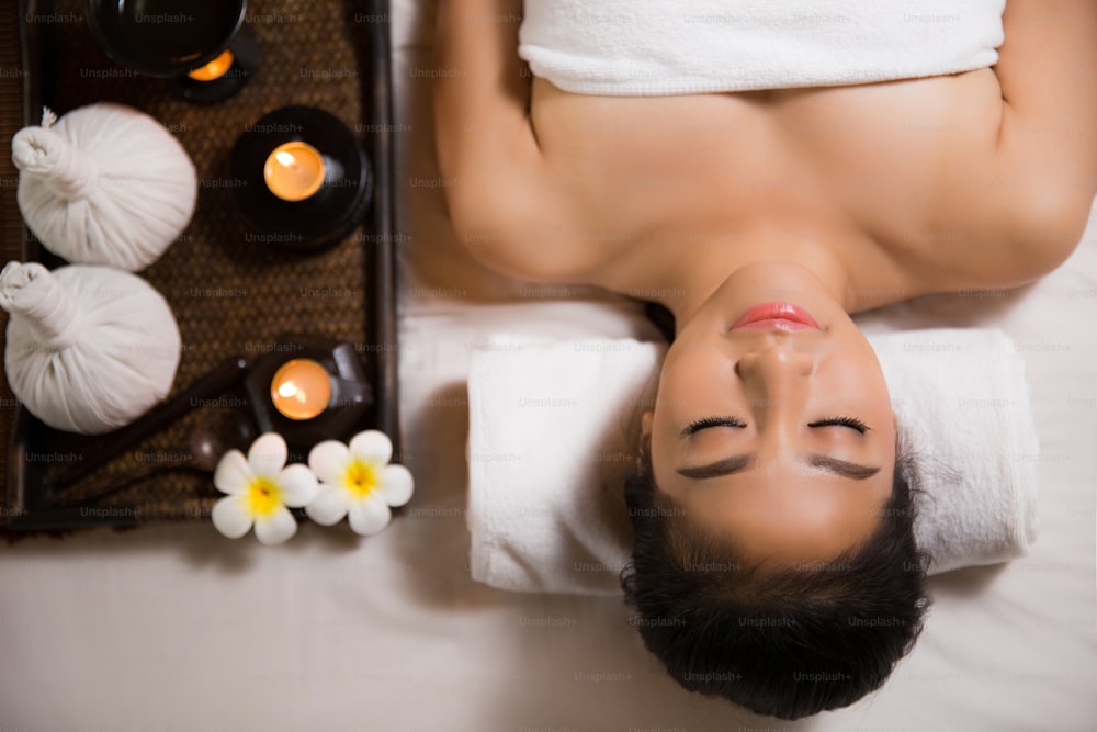 Asiatische Frau mit Massage und Spa-Salon Schönheitsbehandlungskonzept. Sie ist sehr glücklich