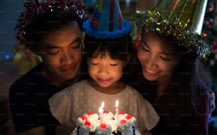 Familia asiática Una fiesta de cumpleaños para la hija de su hija está a punto de apagar las velas.