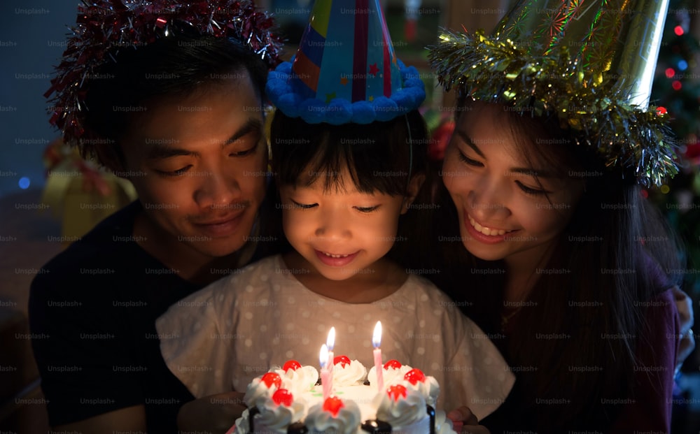 Une famille asiatique une fête d’anniversaire pour la fille de sa fille est sur le point de souffler les bougies.