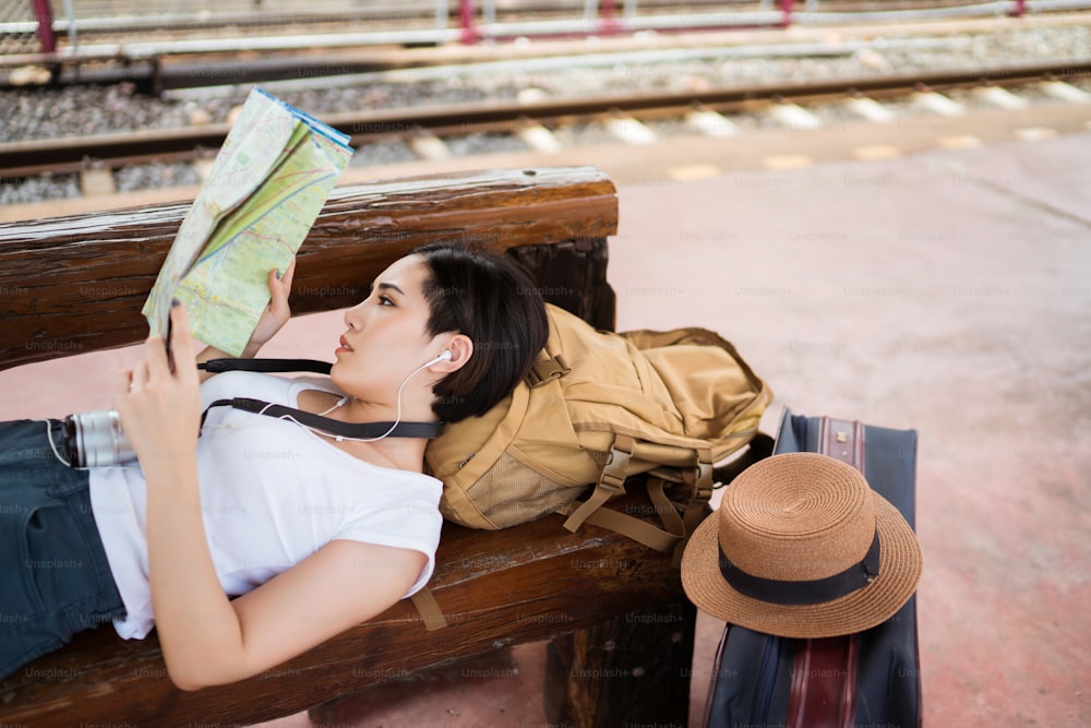 電車に乗った女性旅行者は、地図を読んでいる観光スポットを見に行きました。