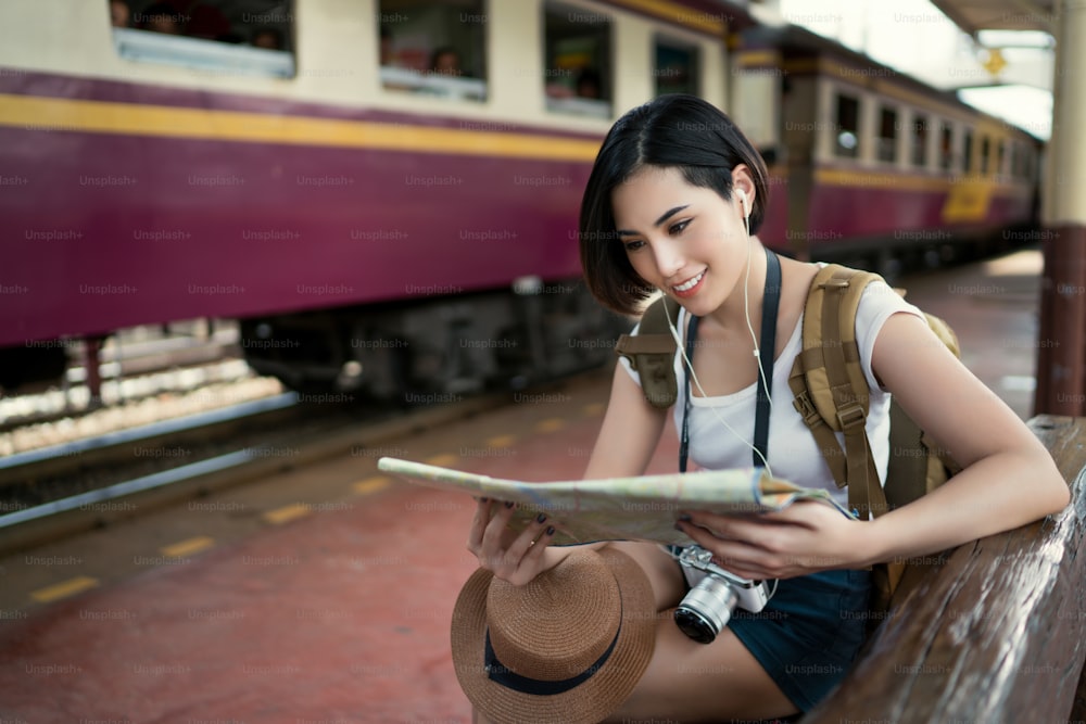 電車に乗った女性旅行者は、地図を読んでいる観光スポットを見に行きました。