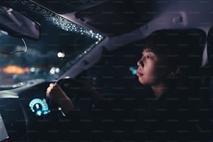 Mujeres asiáticas Está lloviendo mientras conduzco a casa desde el trabajo.