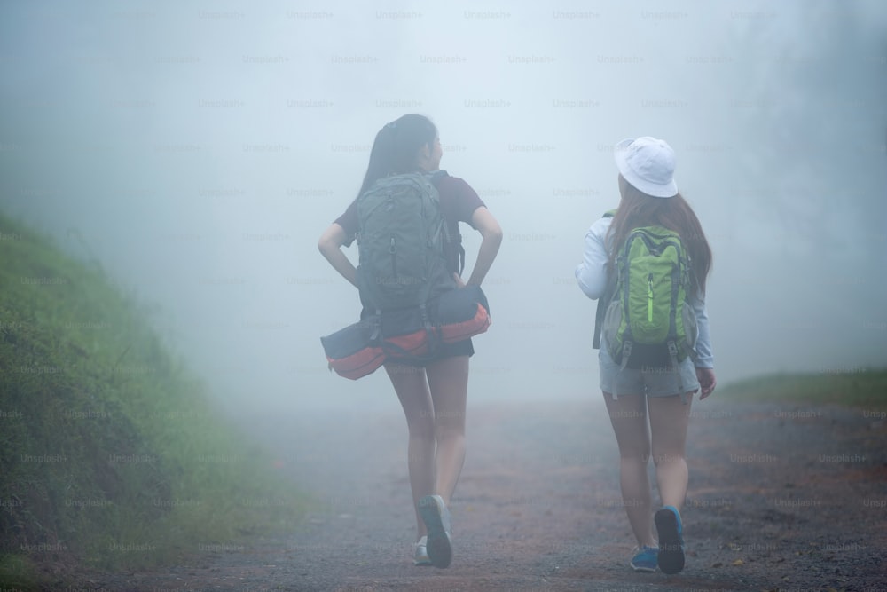 I turisti che viaggiano camminano in presenza di nebbia.