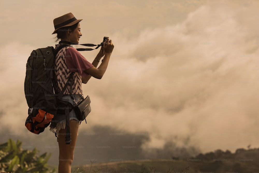 Asian woman traveling backpack her photography morning fog.She travel alone