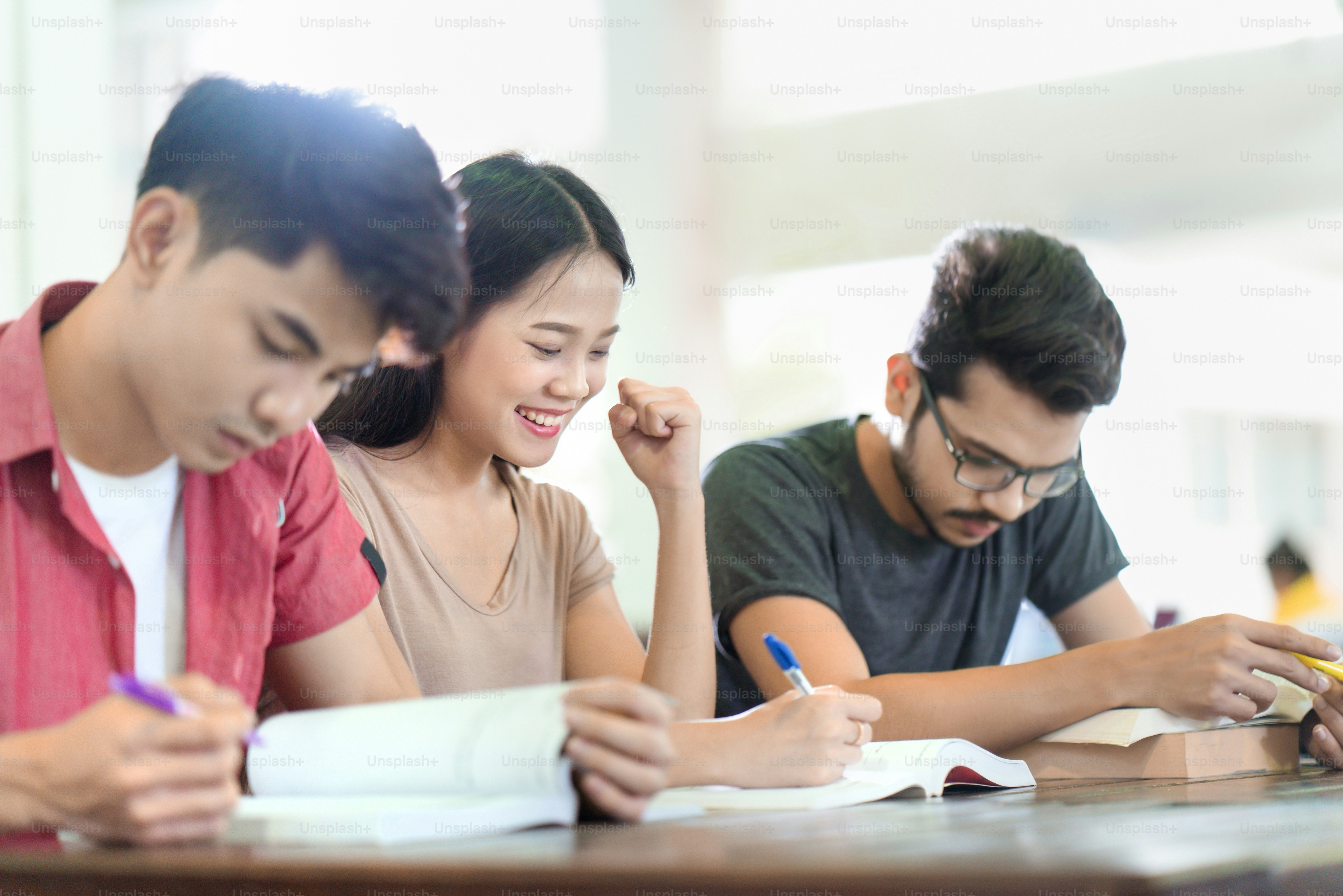 Asiatische Studenten lesen Bücher. in der Universitätsbibliothek. Sie war froh über das Leseverständnis