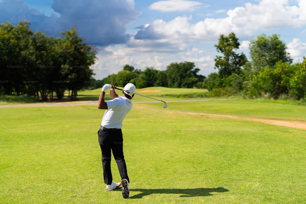 Asian man golfing on the course. In summer