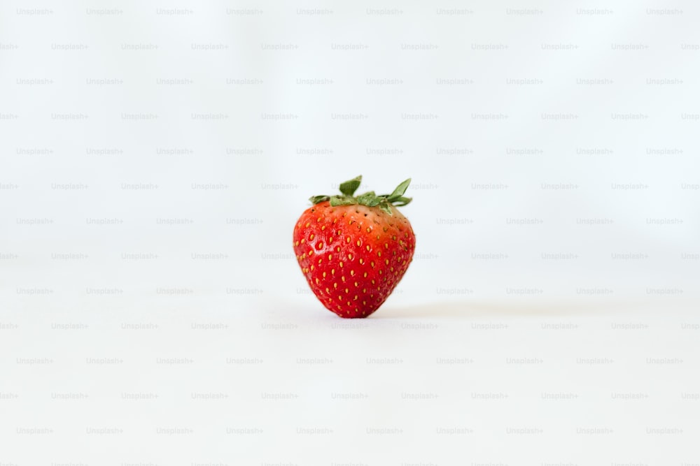 a red strawberry with a green stem