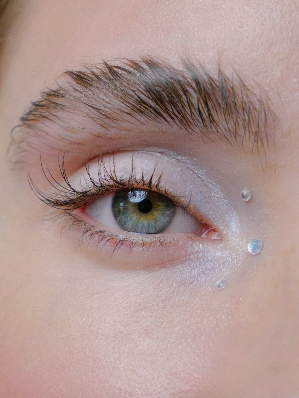 um close up do olho de uma pessoa com gotas de água sobre ele