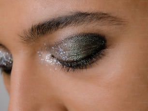 a close up of a woman's eye with glitter on it
