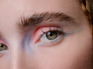 um close up do olho de uma mulher com maquiagem rosa e azul