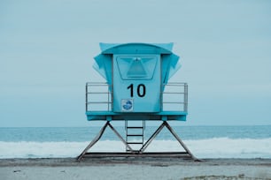 a blue and white water tower on a beach