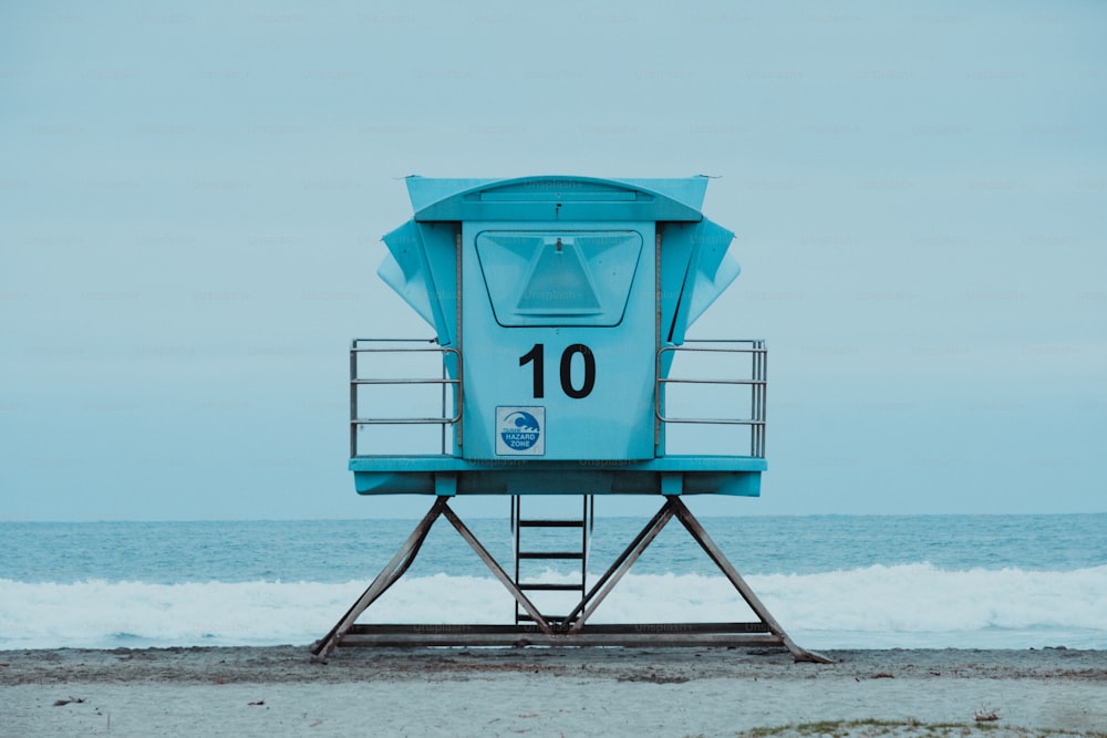 uma torre de água azul e branca em uma praia