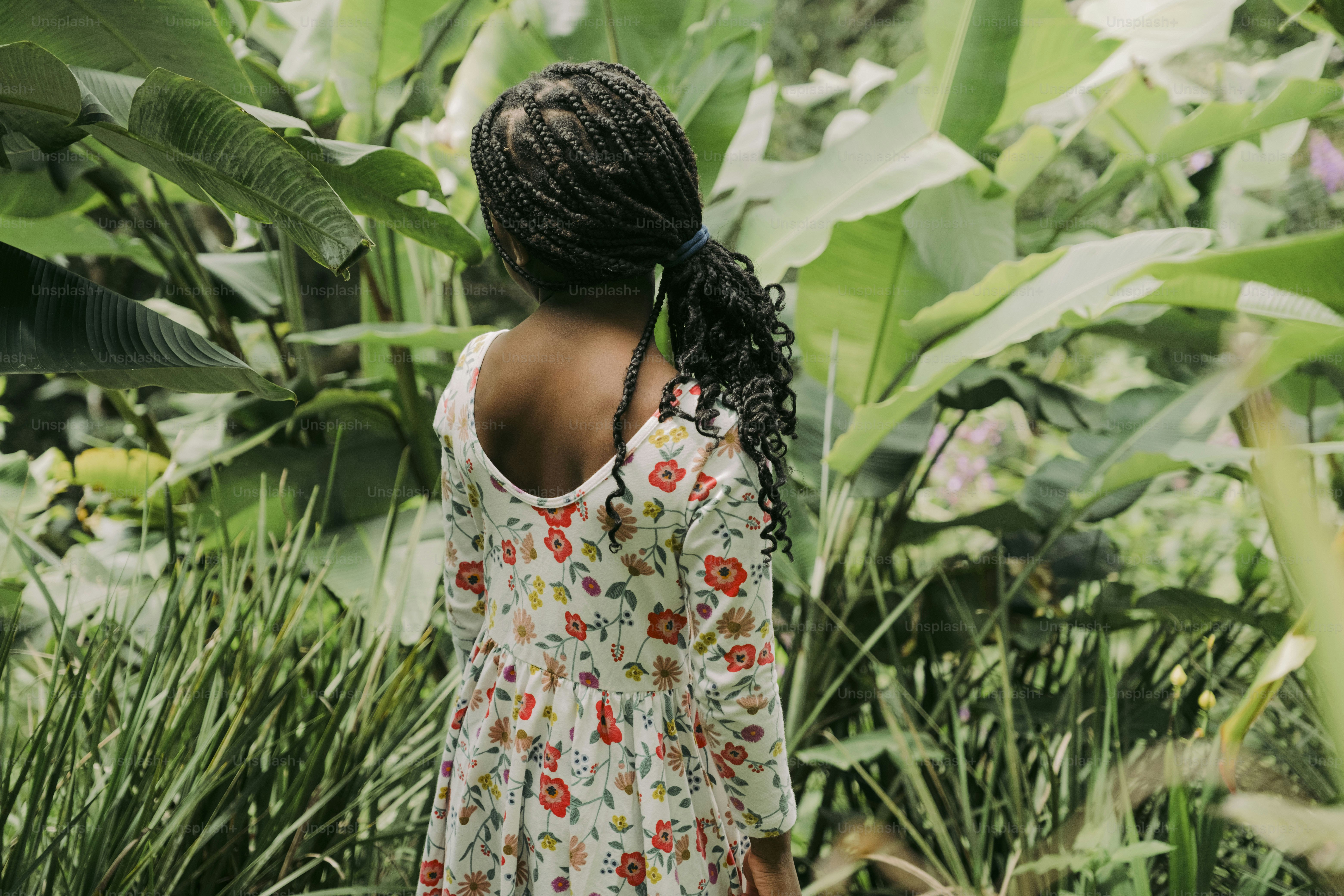 a person standing in front of a tropical plant