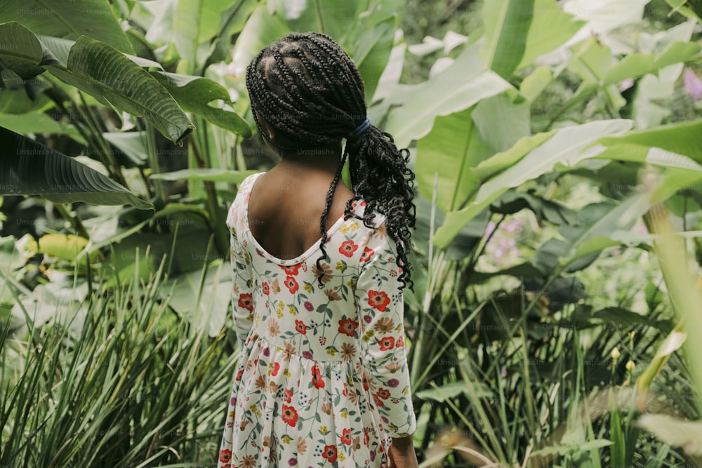 una persona in piedi di fronte a una pianta tropicale