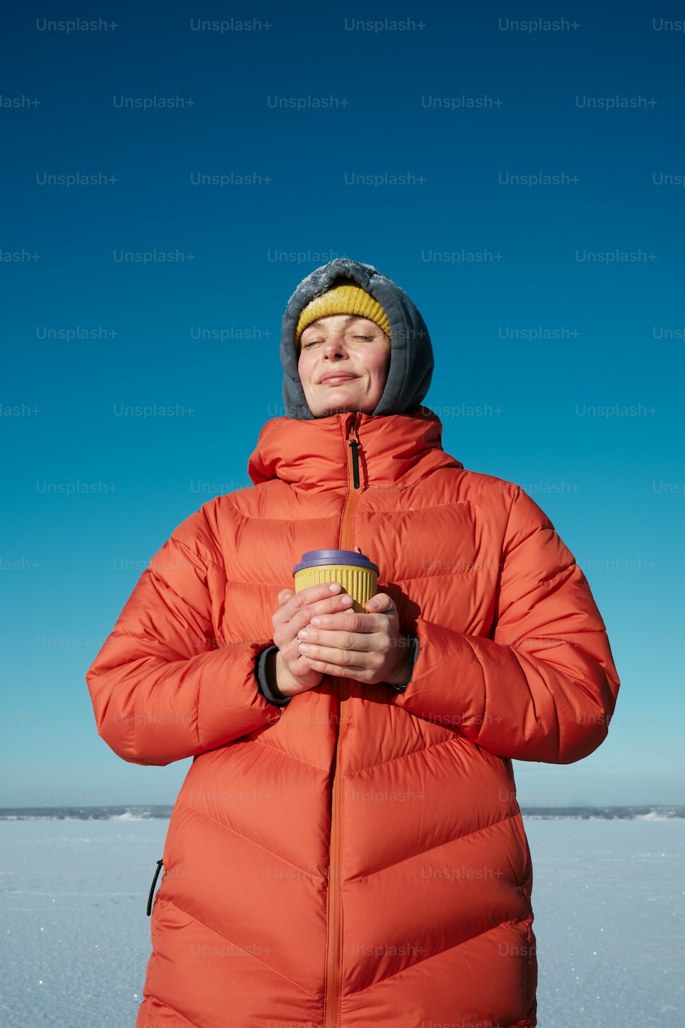 a person in a red coat holding a cup of coffee