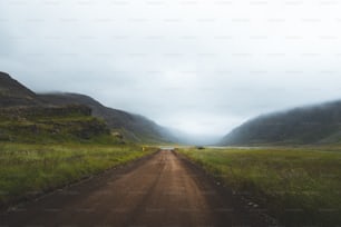 Una strada sterrata in una valle erbosa