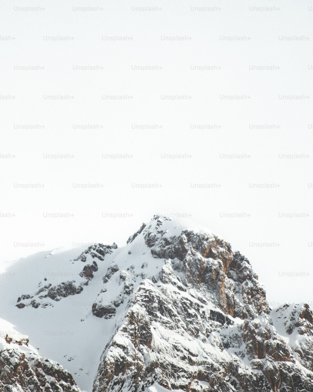 Una montagna innevata con un cielo nebbioso