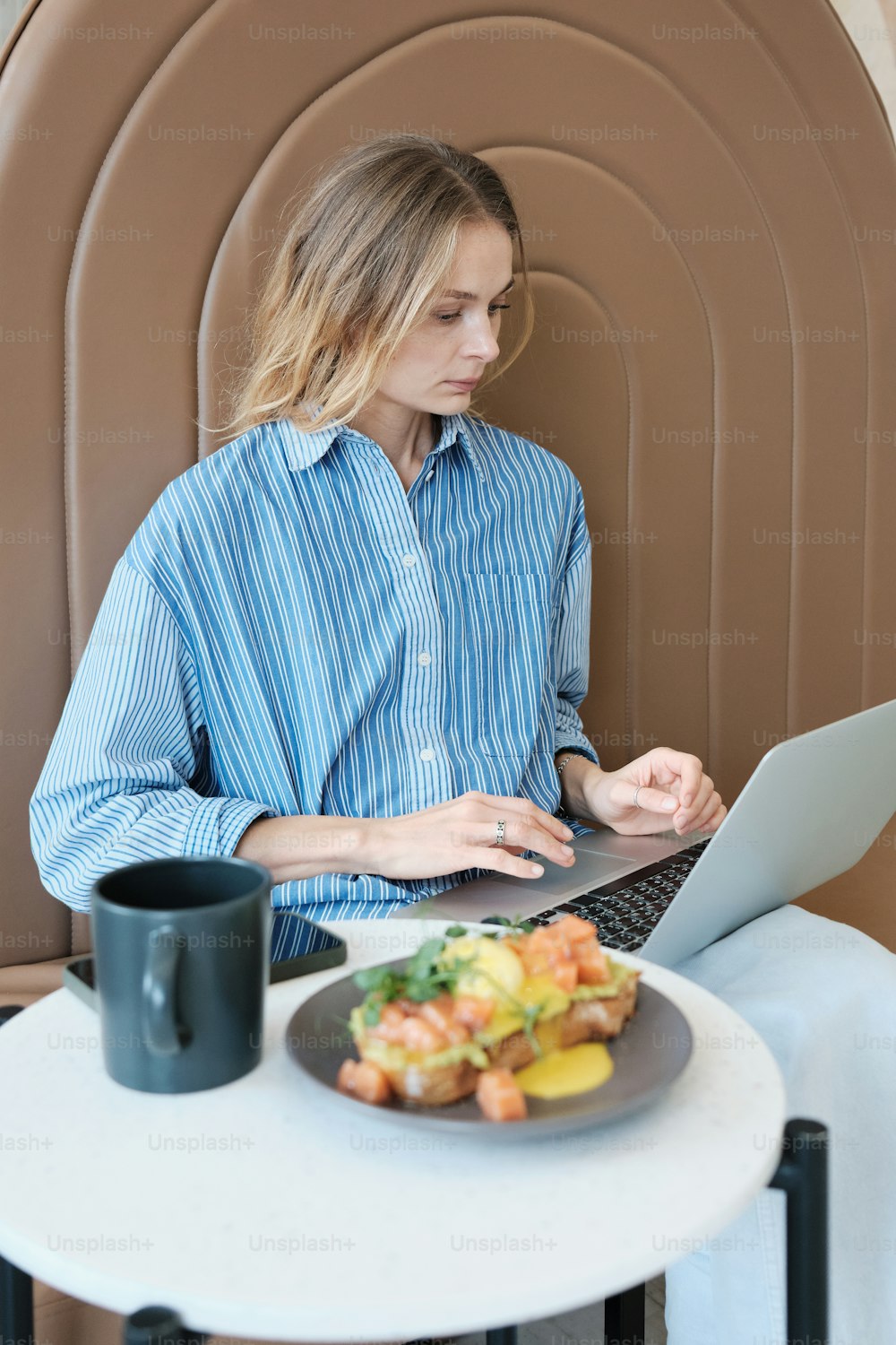 eine Person, die an einem Tisch mit einem Teller Essen sitzt