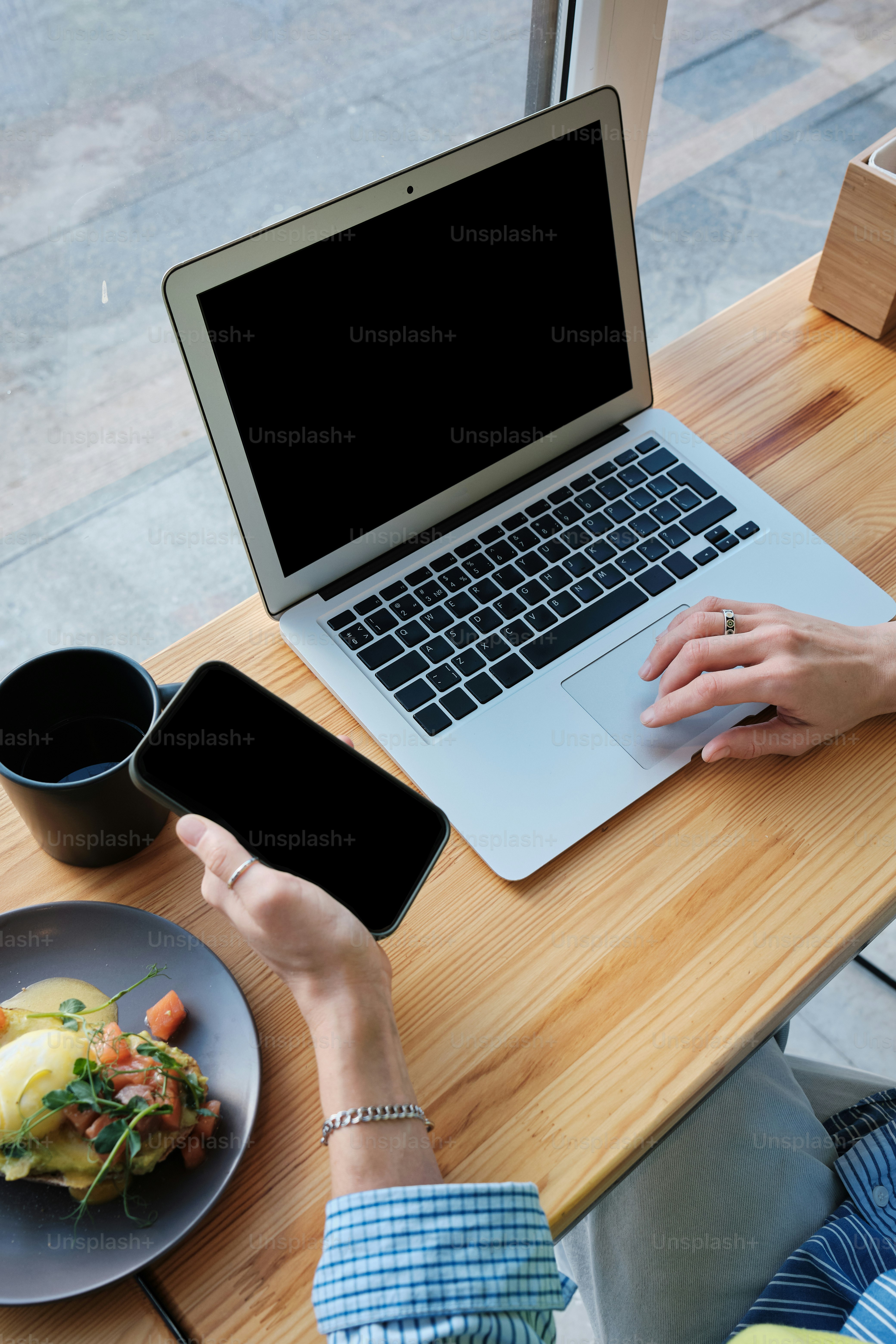 携帯電話とラップトップを持っている人