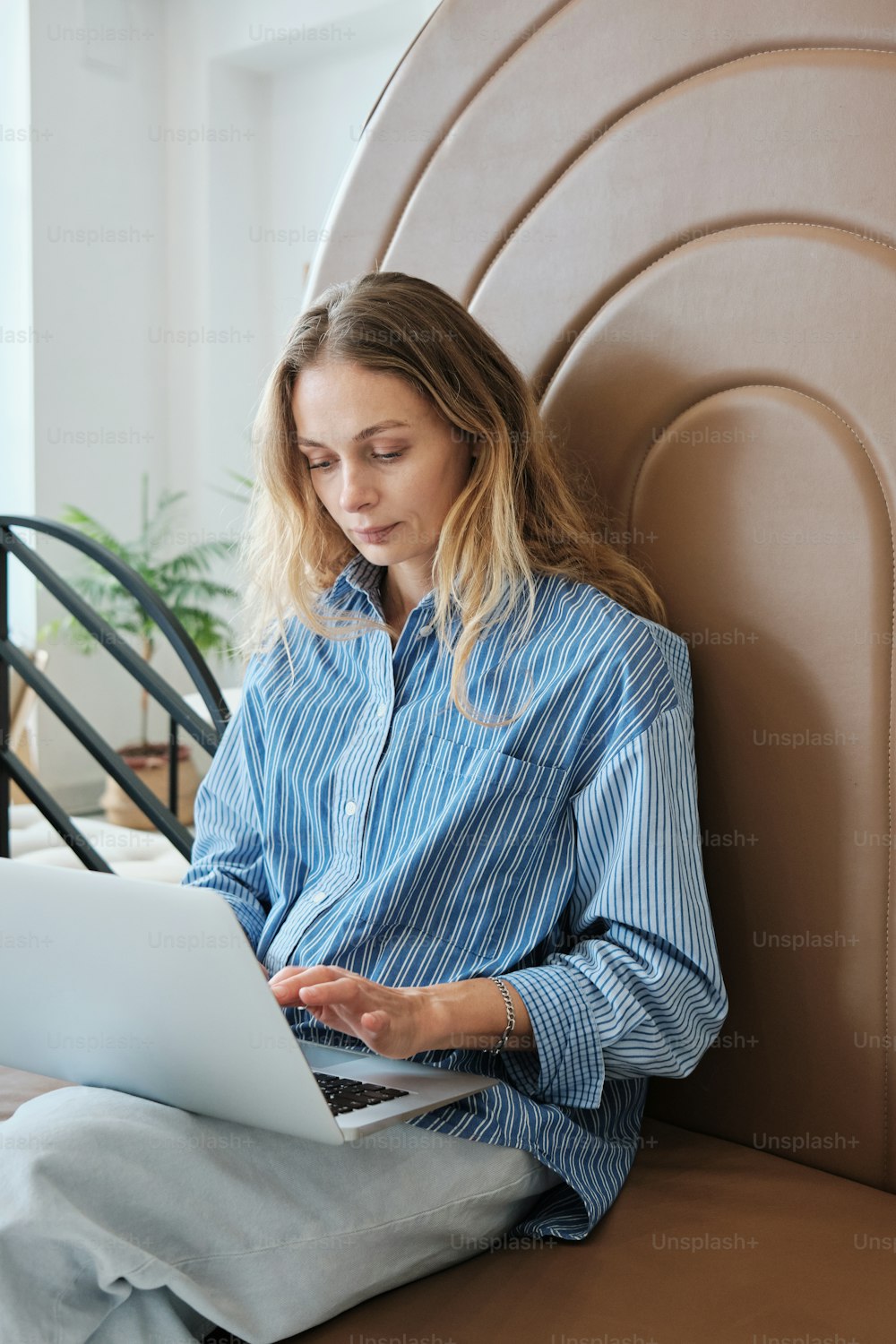 Una persona sentada en una silla usando una computadora portátil