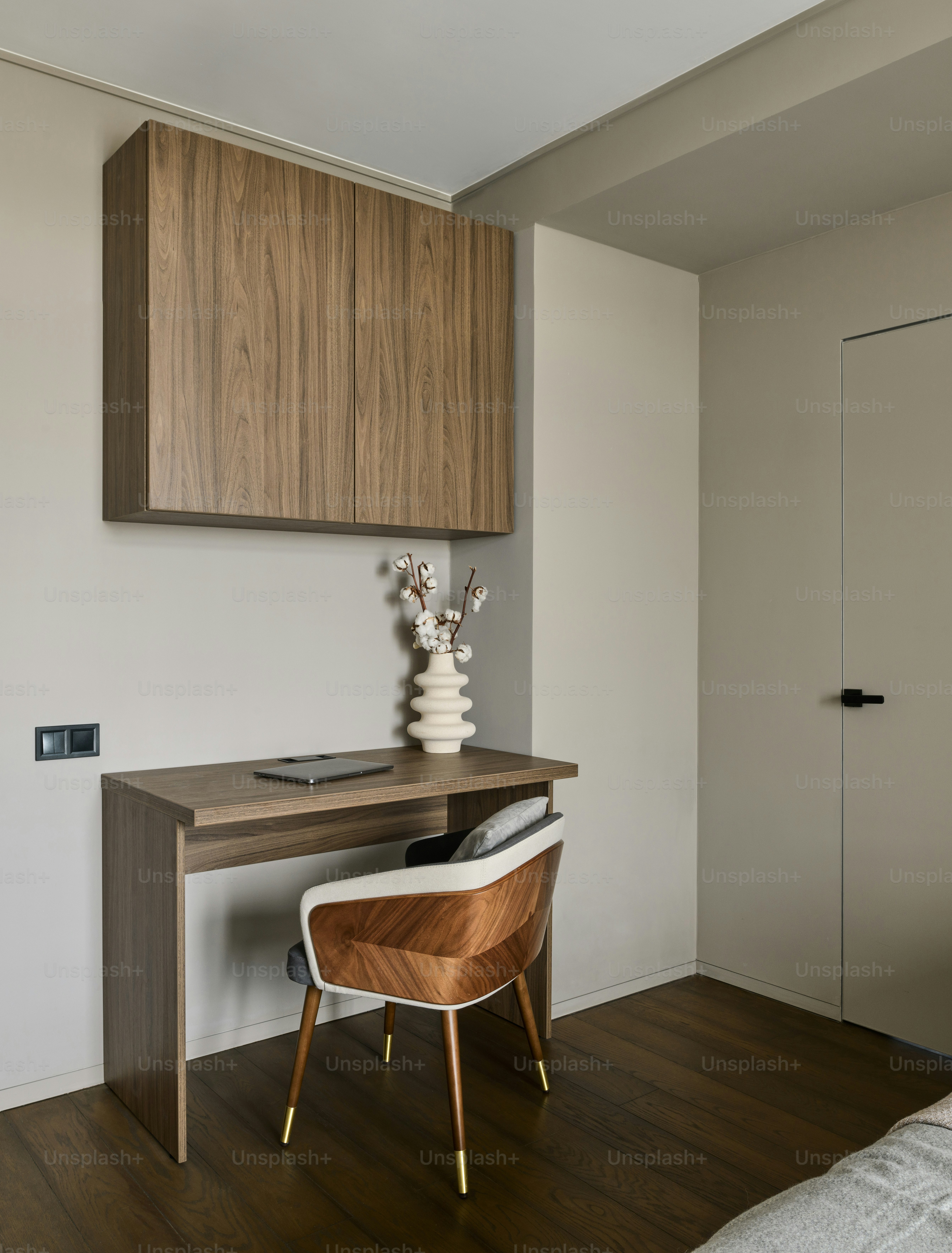 un bureau avec une chaise et un vase dessus