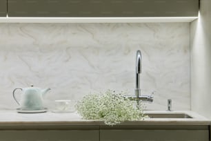 a white bathroom with a sink and a plant