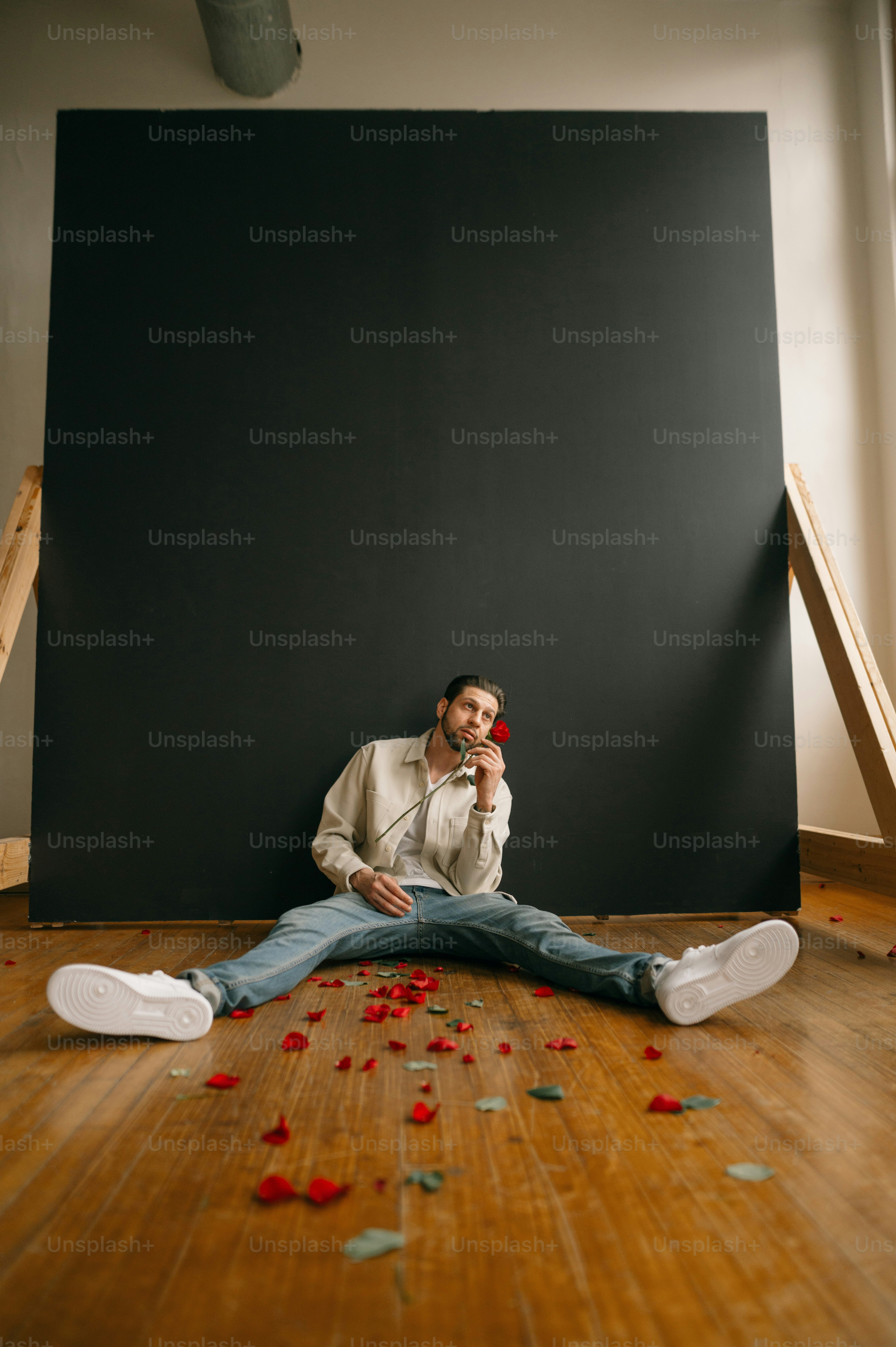 a person sitting on the floor with a blackboard and white shoes
