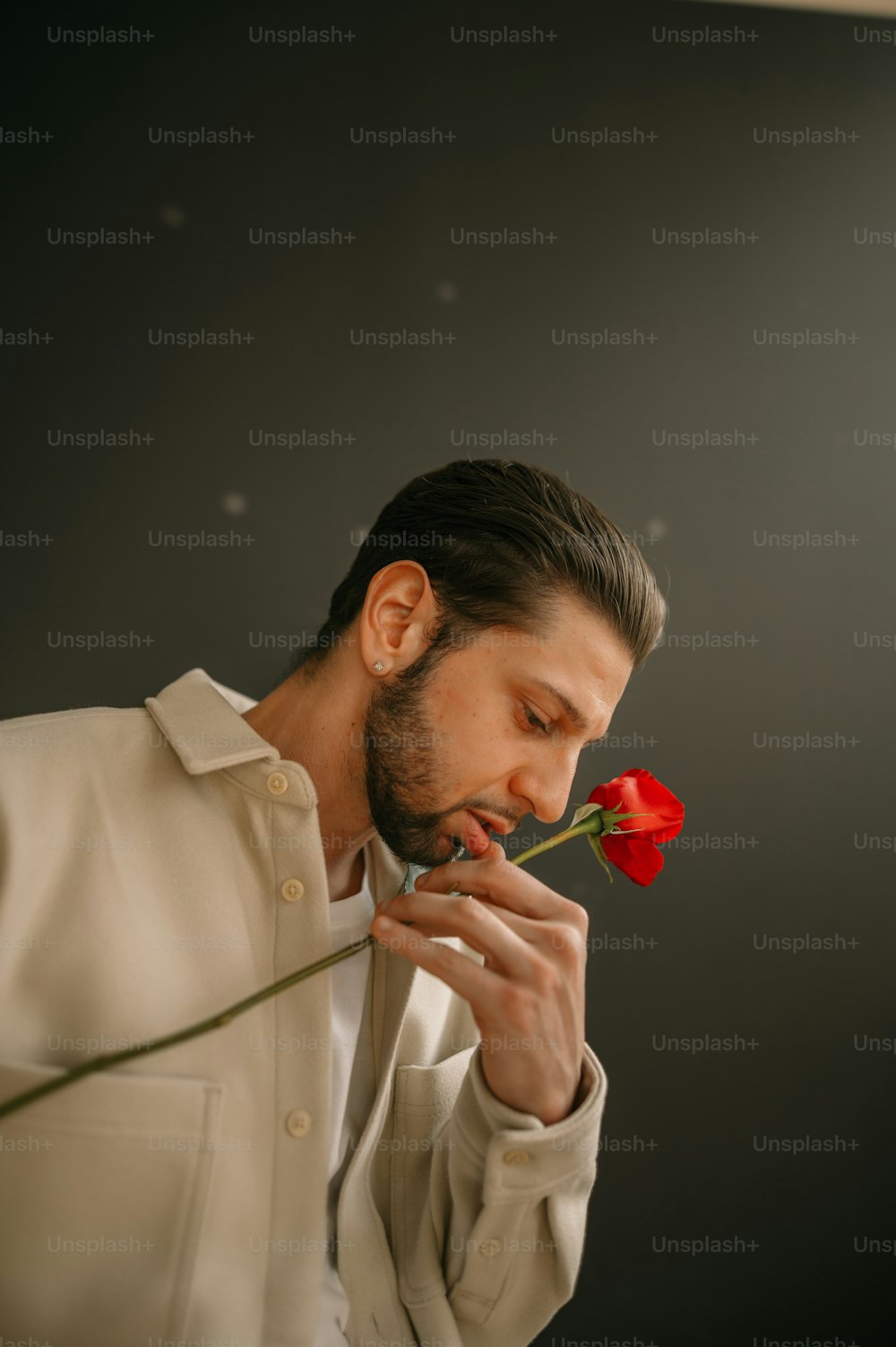 Un hombre oliendo una rosa
