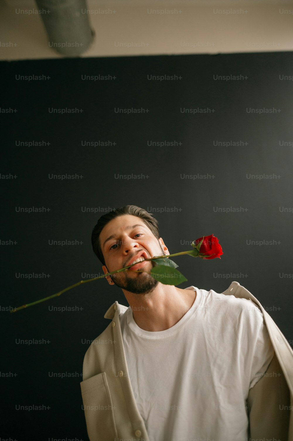 una persona con una rosa in bocca
