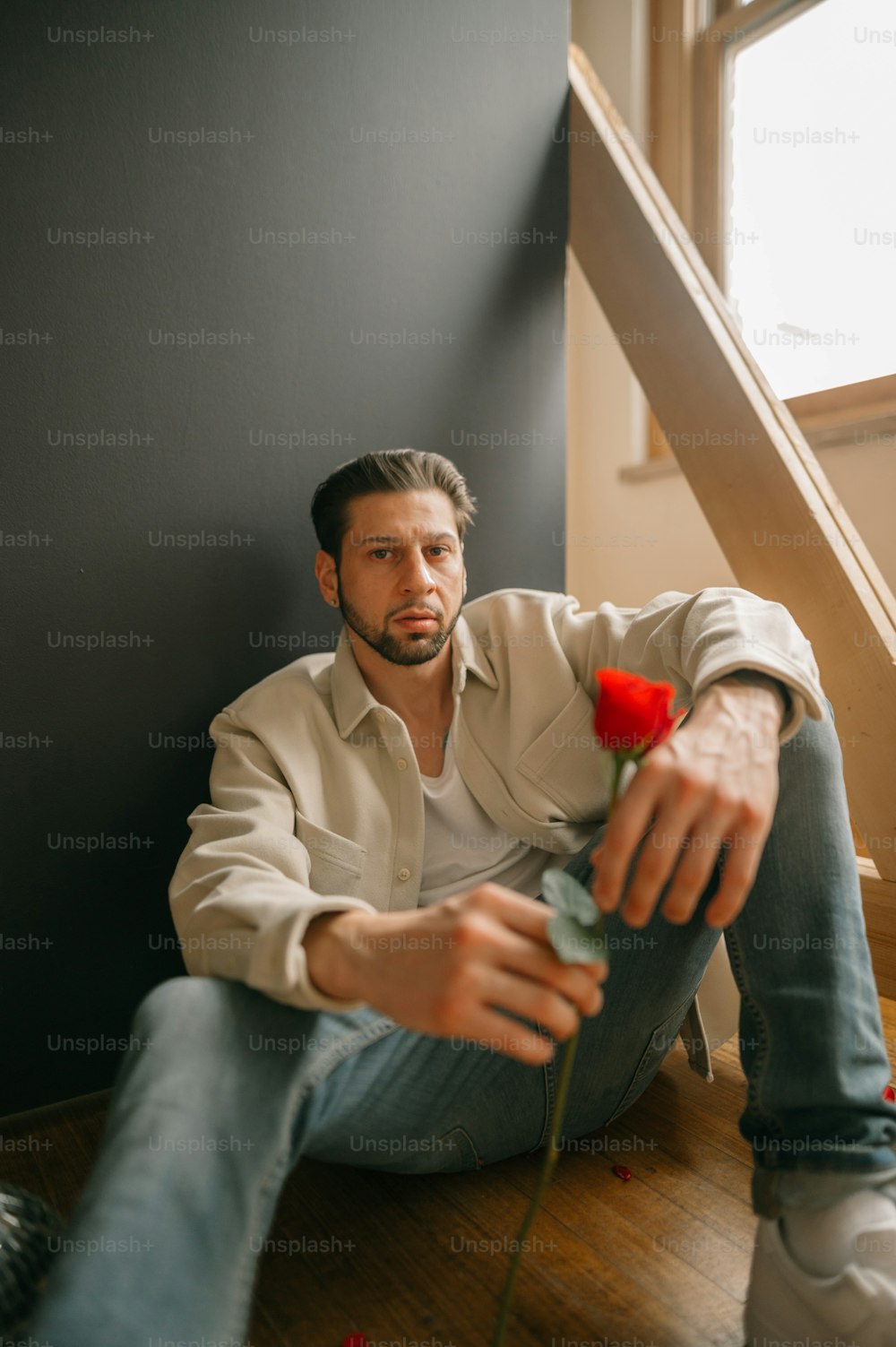 a man sitting on a chair holding a rose