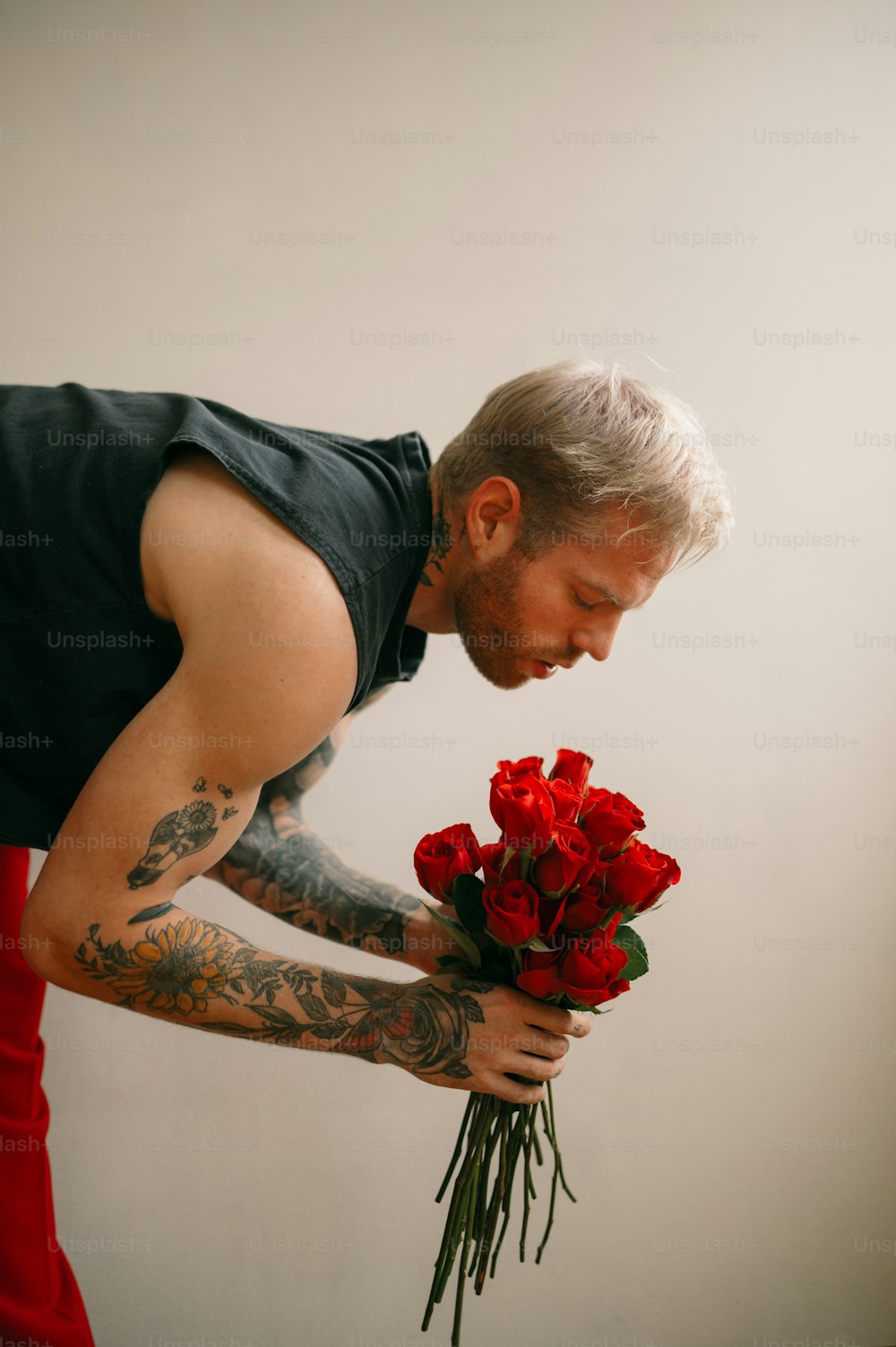 Un hombre sosteniendo un ramo de flores rojas