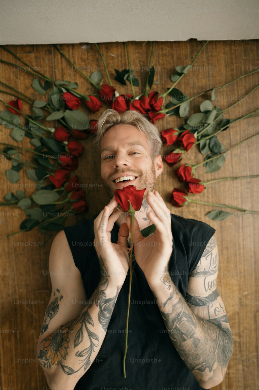 Una persona con bigote sosteniendo una rosa