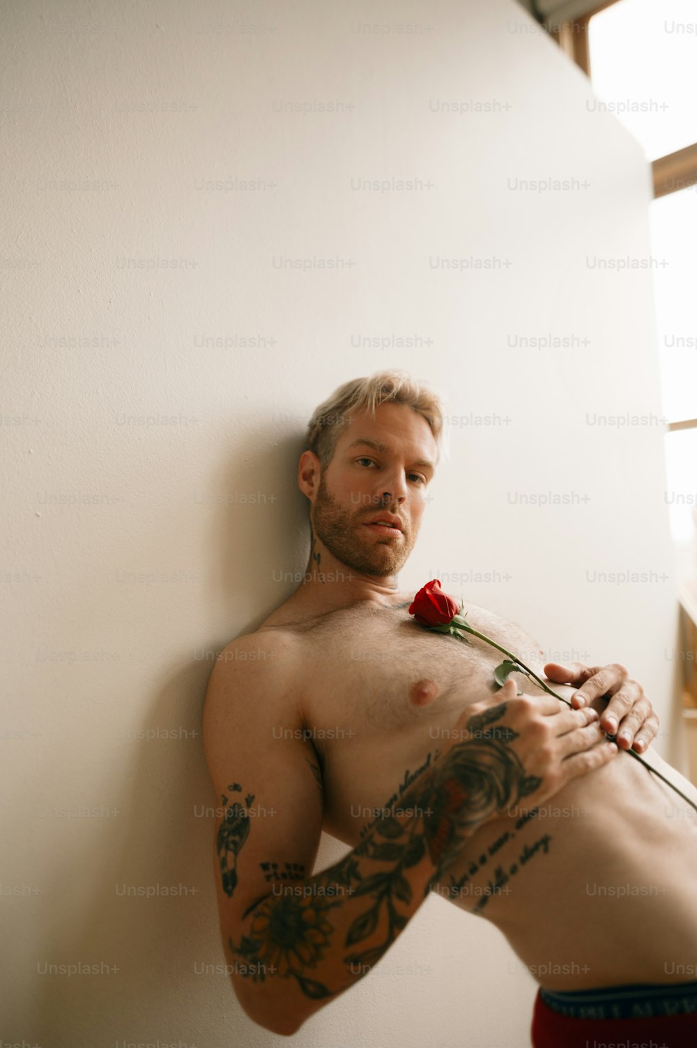 uma pessoa com tatuagens segurando uma rosa