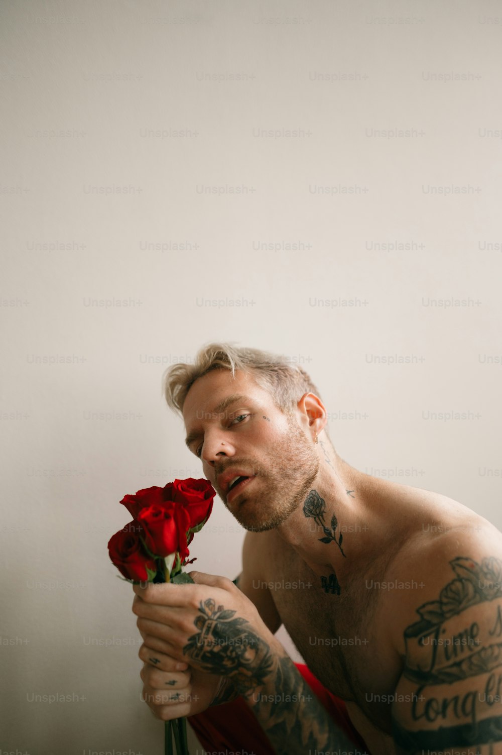 a person with tattoos holding a rose
