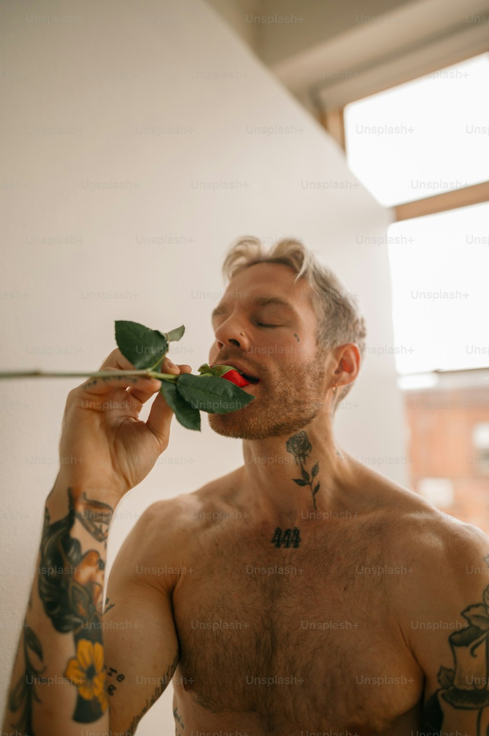 a person with a tattoo on the arm and a plant in the mouth