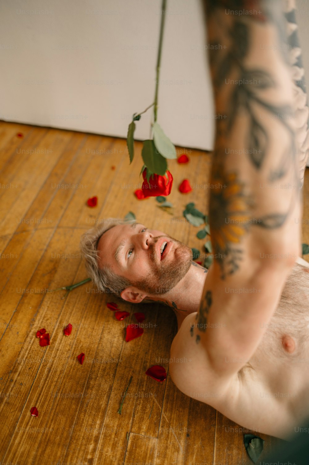 a person lying on the floor with red flowers on the head