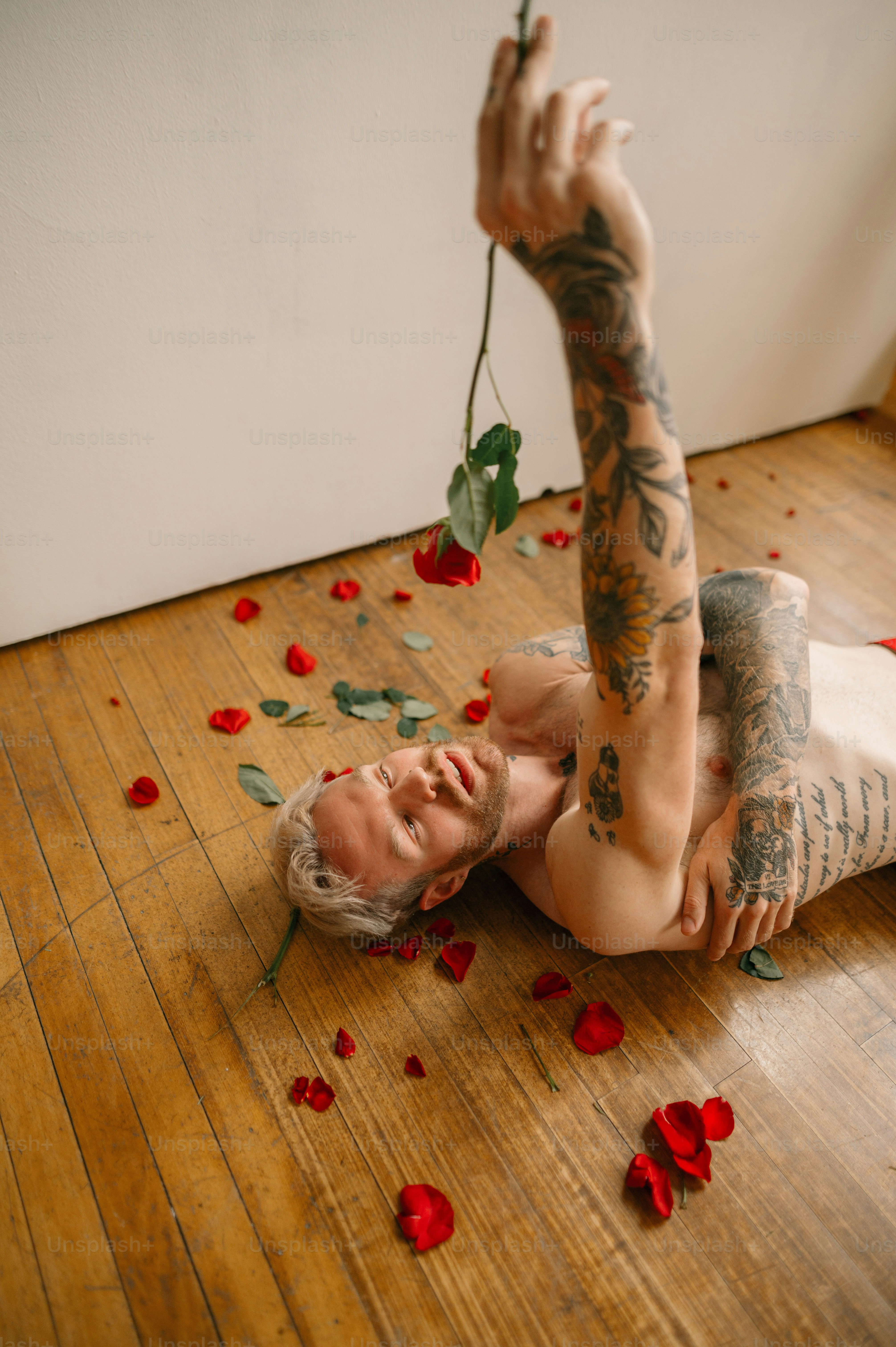 eine Person, die mit einem Haufen roter und grüner Gegenstände auf dem Boden liegt