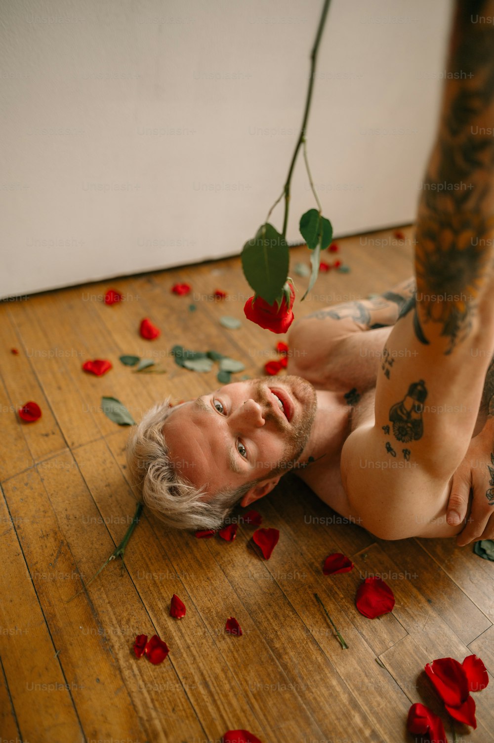 a person lying on the floor with red and green objects on the floor