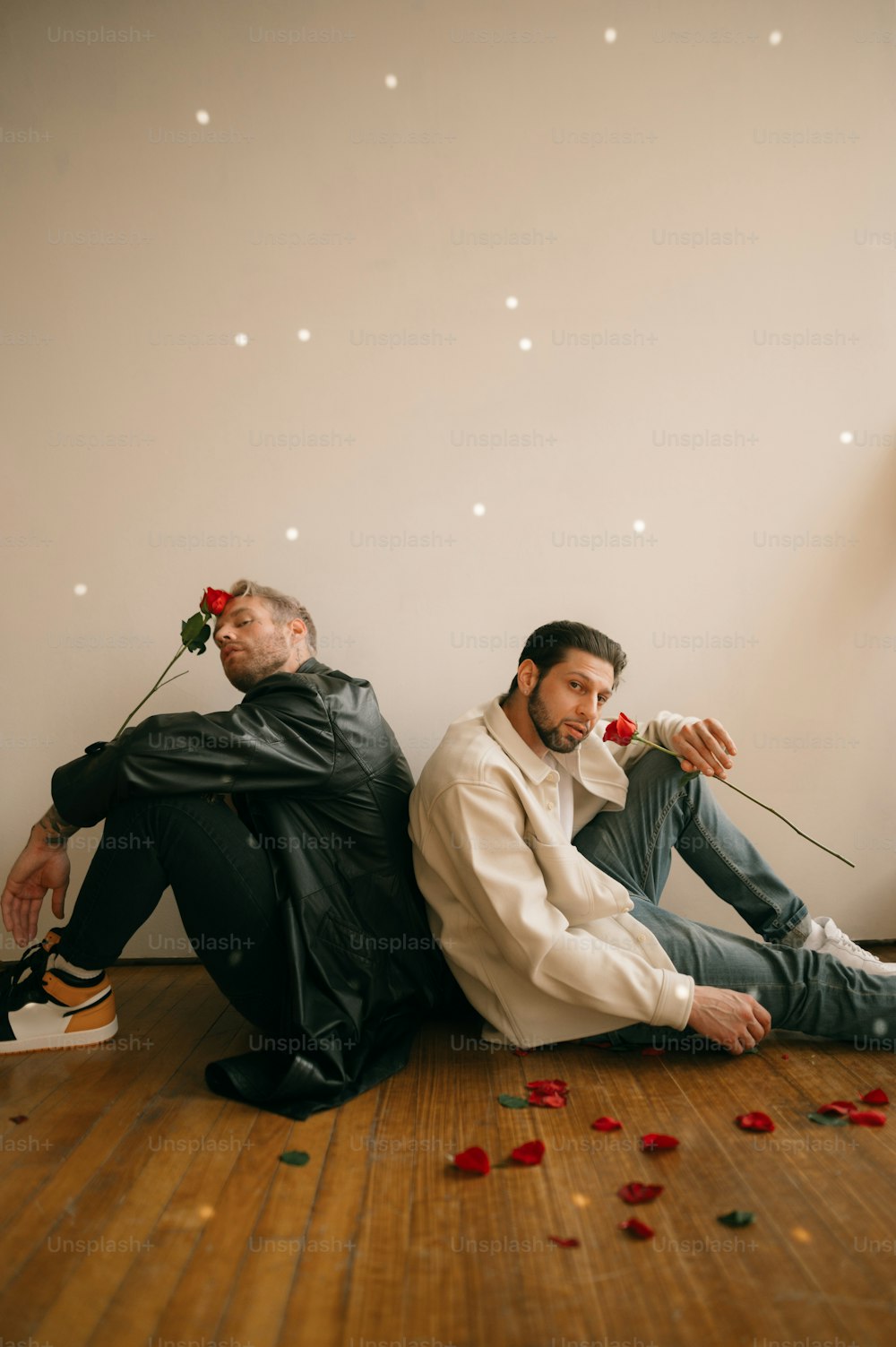a couple of men sitting on the floor with a bouquet of flowers