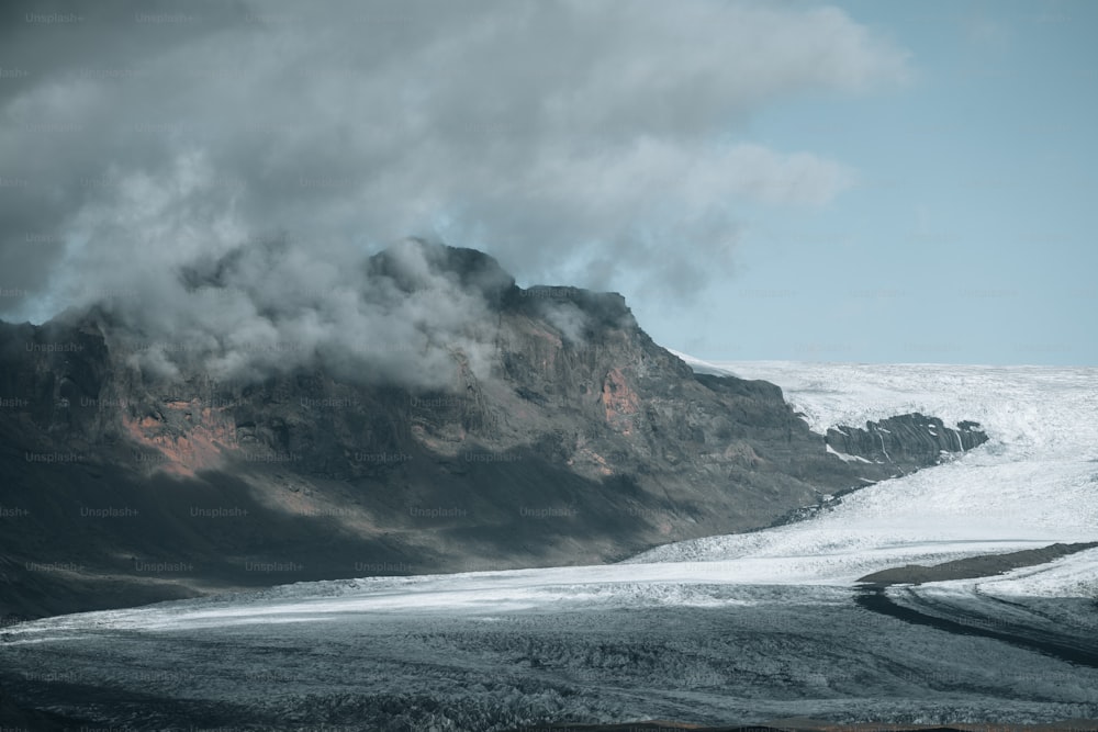 a snowy mountain with clouds