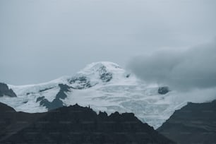 a snowy mountain with clouds