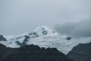 Ein schneebedeckter Berg mit Wolken