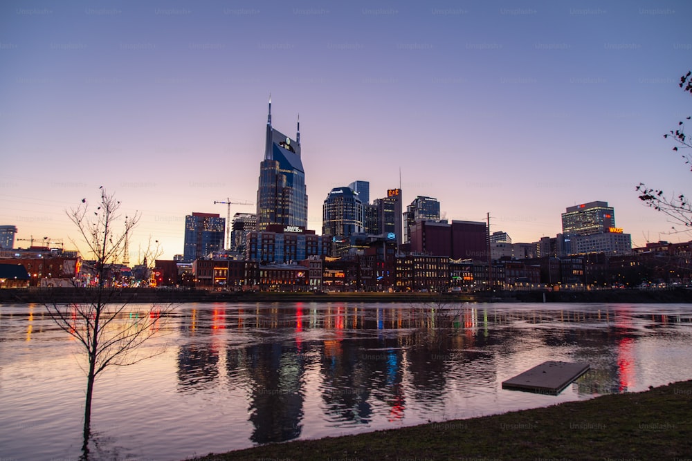 a city skyline with a body of water in front of it