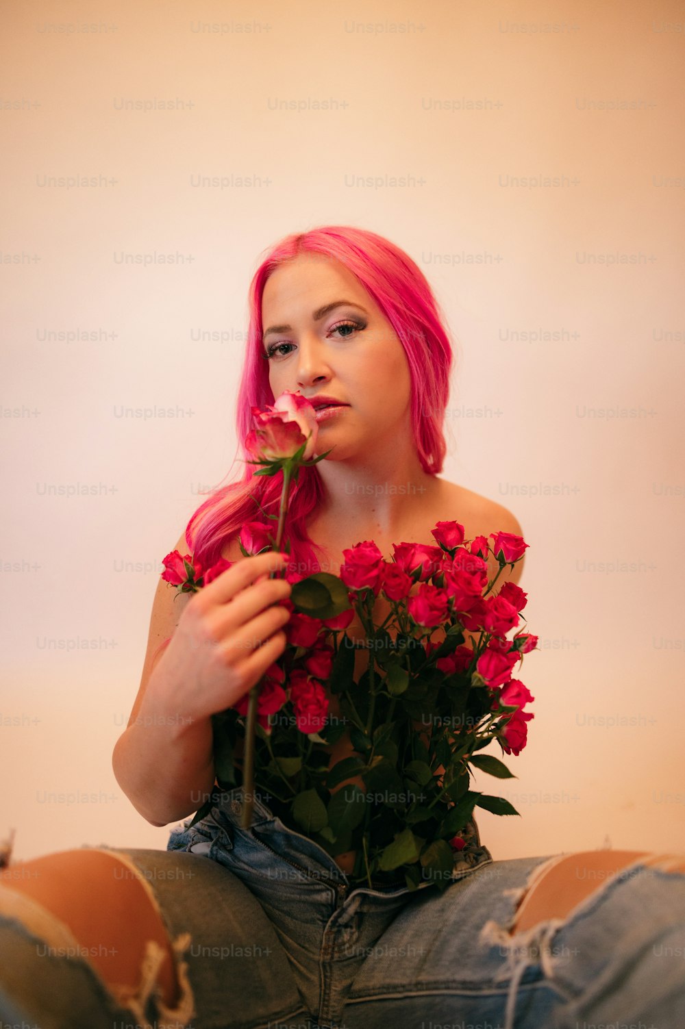 a person with pink hair holding a bouquet of flowers
