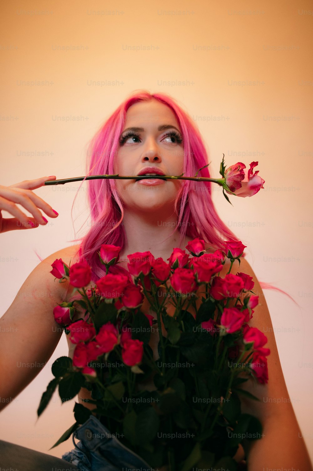 a woman with pink hair holding a bouquet of flowers